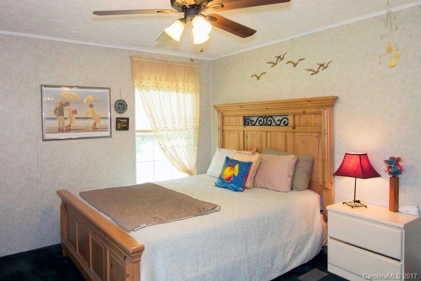 150 Buck Branch Rd Mill Spring Mill Spring, NC 28756 - Photo 17 of 22 a bedroom with a bed and a chandelier