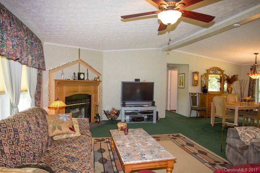 150 Buck Branch Rd Mill Spring Mill Spring, NC 28756 - Photo 4 of 22 a living room with furniture a fireplace and a flat screen tv