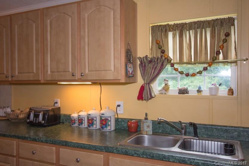 150 Buck Branch Rd Mill Spring Mill Spring, NC 28756 - Photo 8 of 22 a kitchen with granite countertop a sink a stove and cabinets