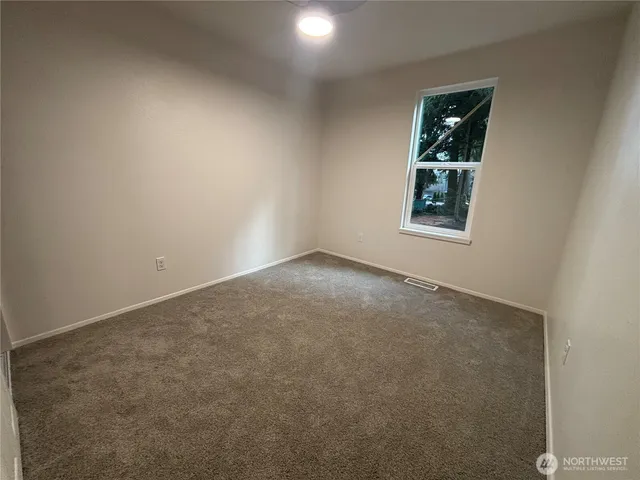an empty room with windows and closet