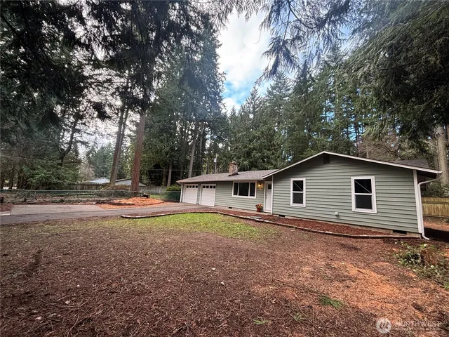 a view of a house with backyard and trees