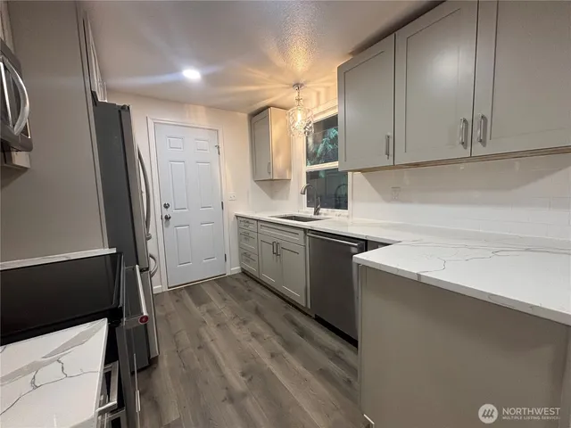 a kitchen with a sink a refrigerator and window
