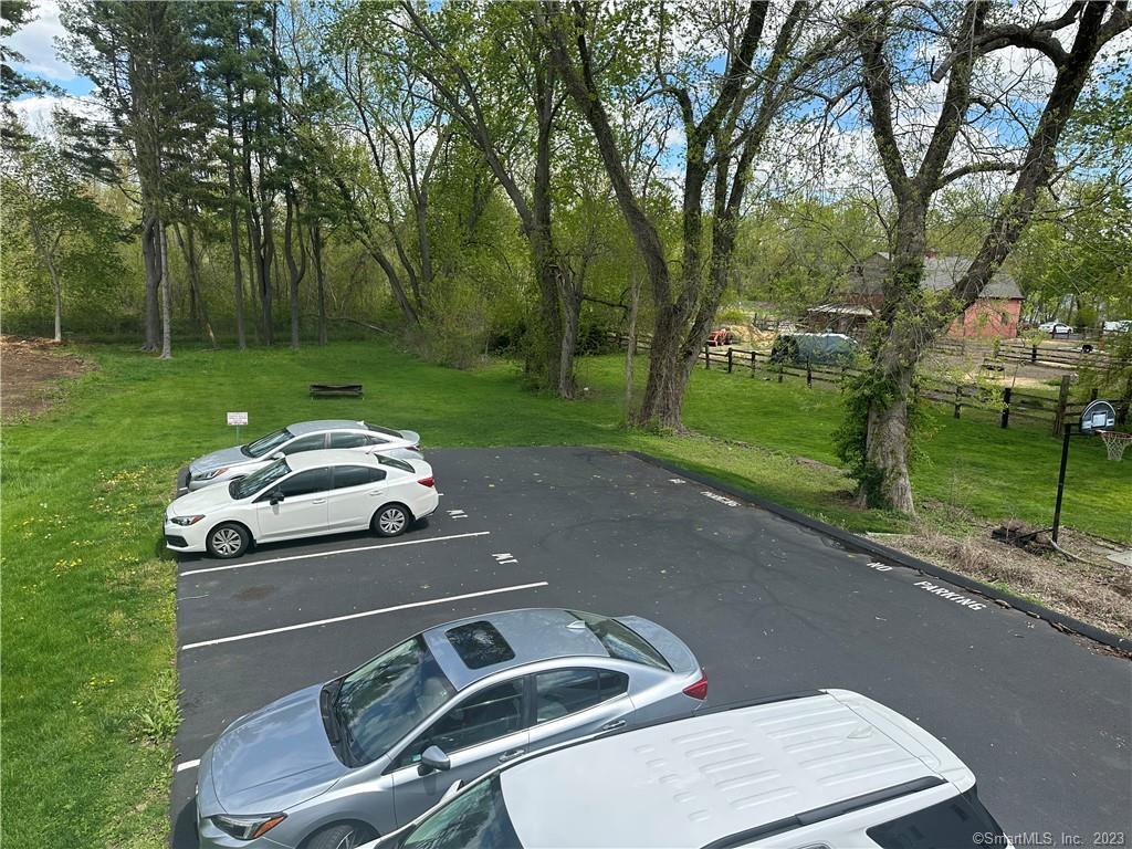 21 Wall Street, Unit 1E Cromwell, CT 06416 - Photo 3 of 16 a white house with a yard and garage