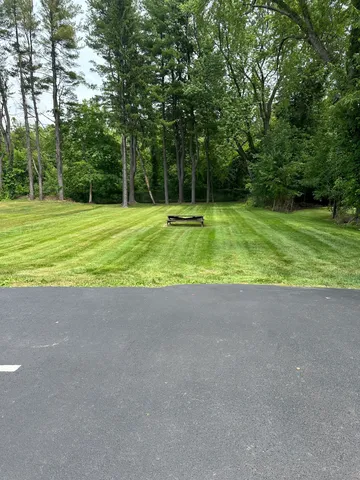 a small yard with trees in the background