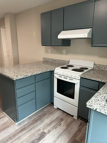 a kitchen with granite countertop a stove a sink and dishwasher