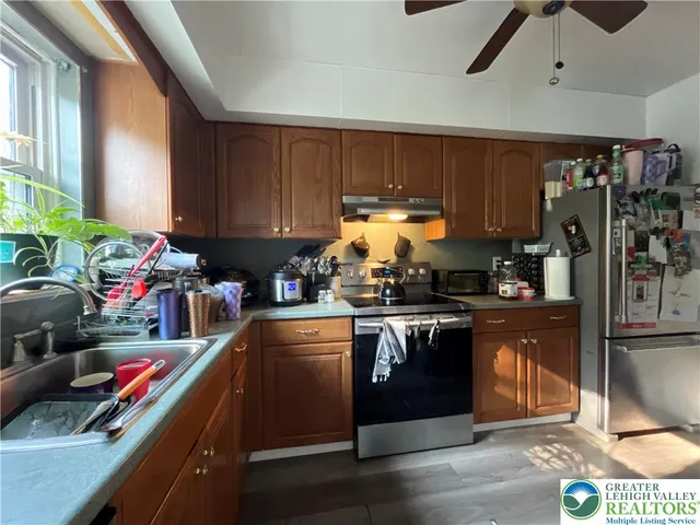 a kitchen with stainless steel appliances granite countertop a stove a sink and a refrigerator