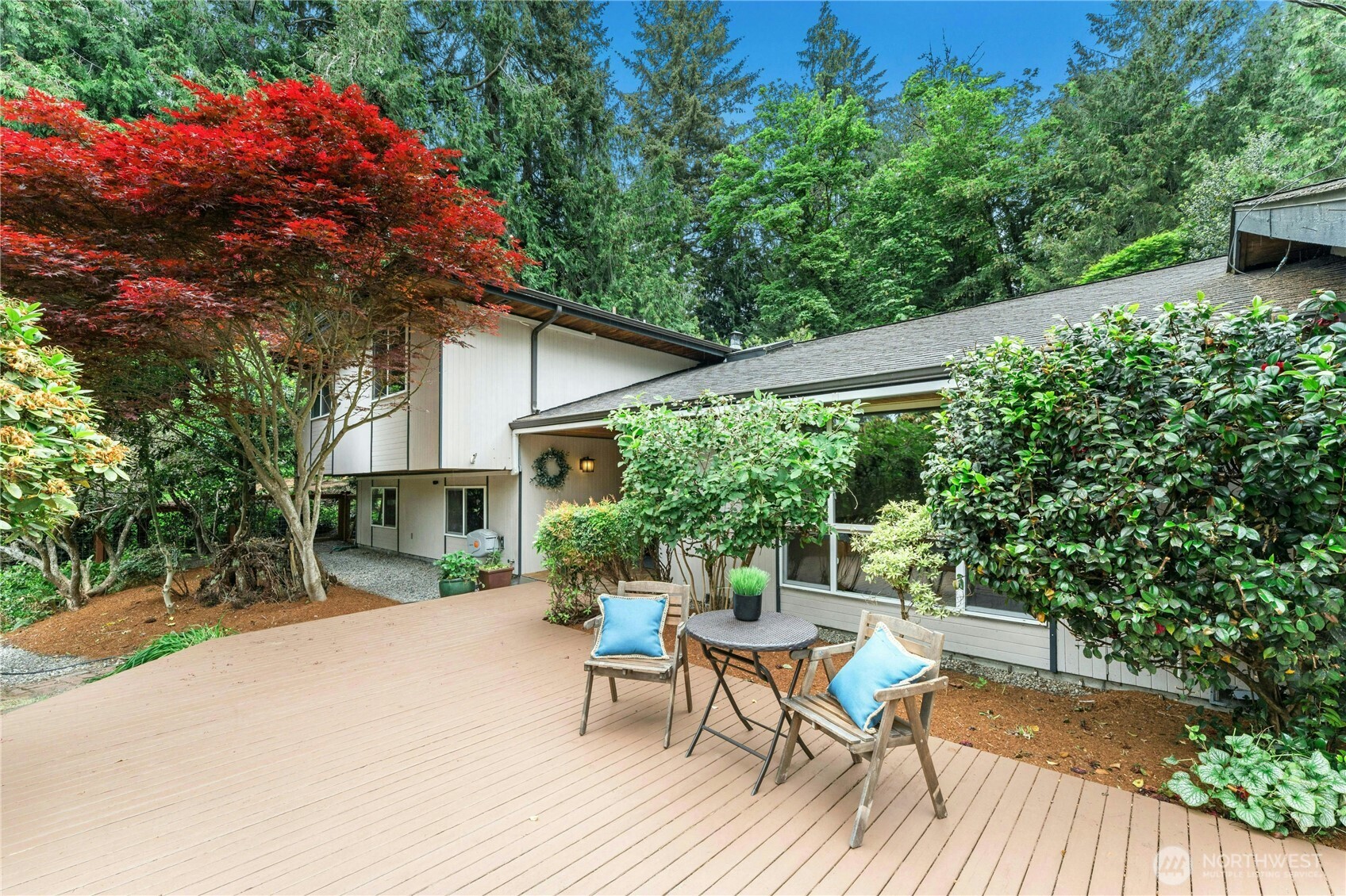 a patio with table and chairs and potted plants