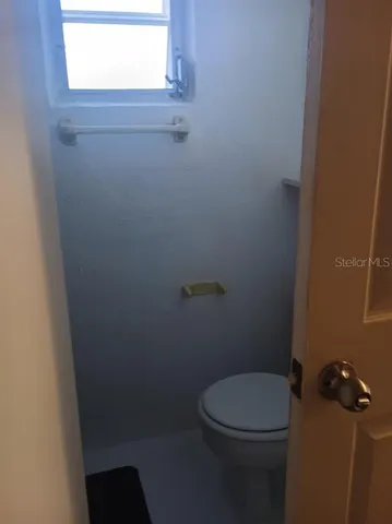 a white toilet sitting next to a window