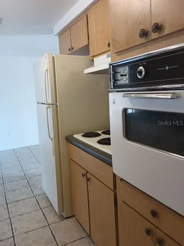 a view of a kitchen with refrigerator stove and sink