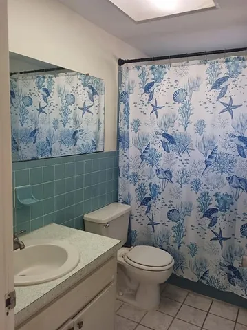 a bathroom with a toilet and a shower curtain