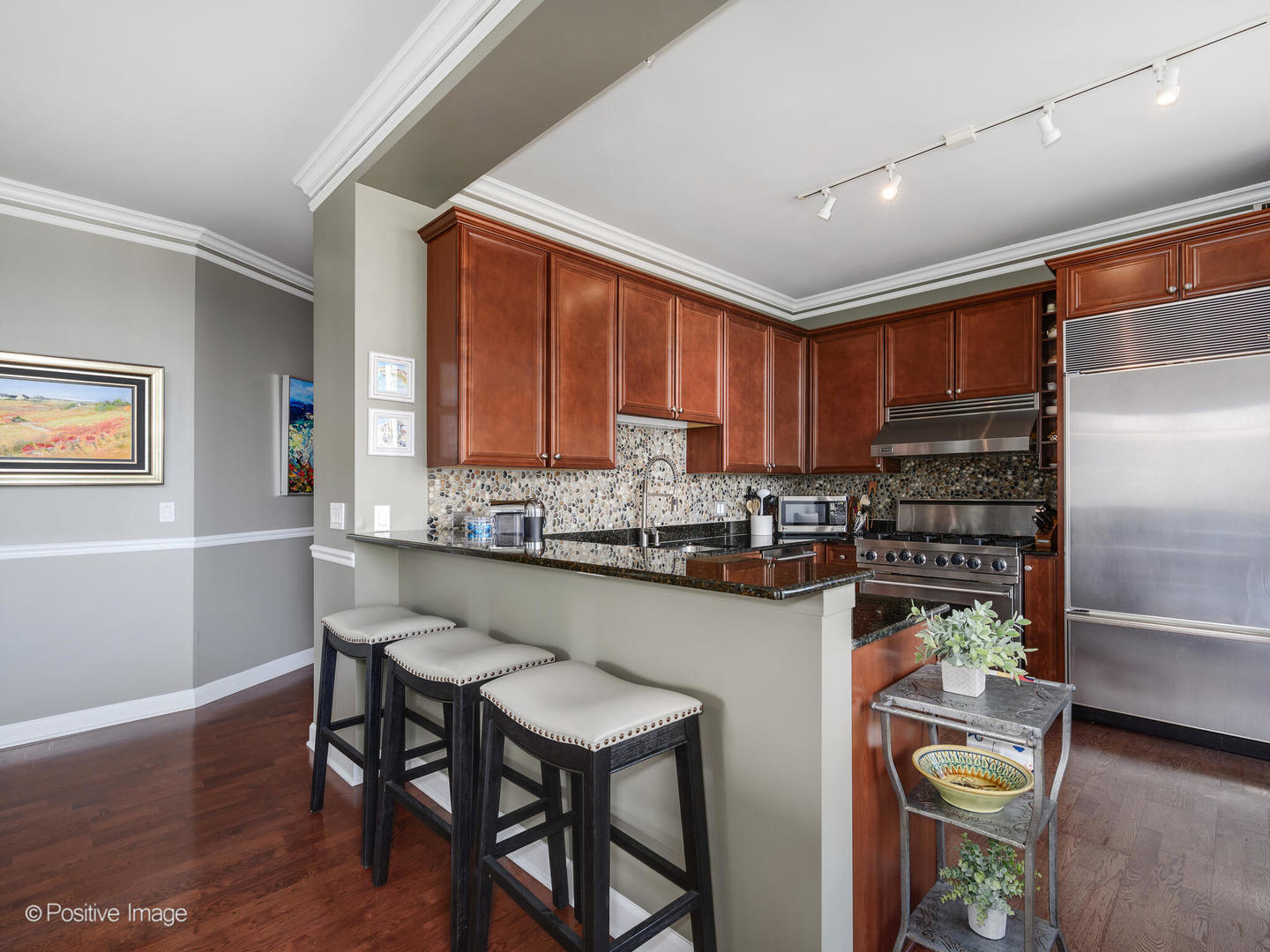 233 East 13th Street, Unit 1209 Chicago, IL 60605 - Photo 11 of 28 a kitchen with stainless steel appliances wooden cabinets dining table and chair