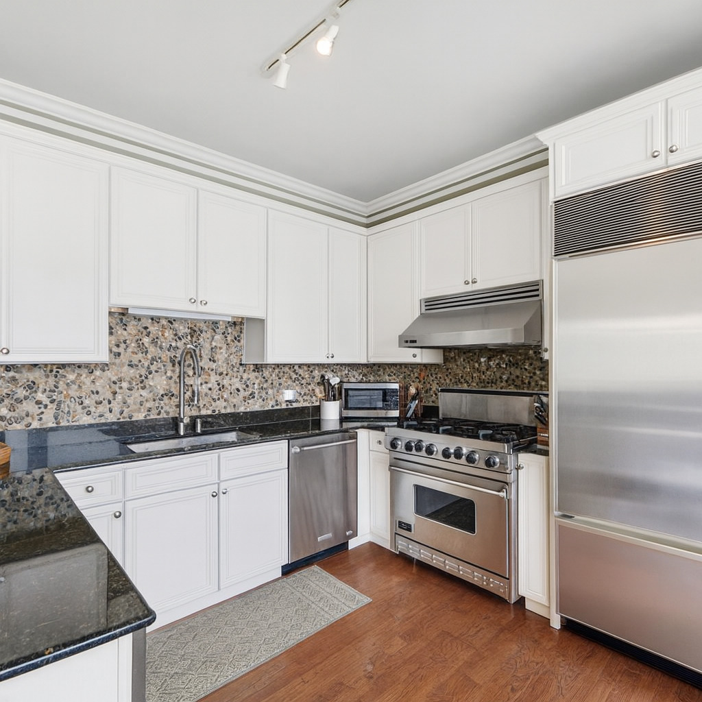 233 East 13th Street, Unit 1209 Chicago, IL 60605 - Photo 13 of 28 a kitchen with granite countertop white cabinets and appliances