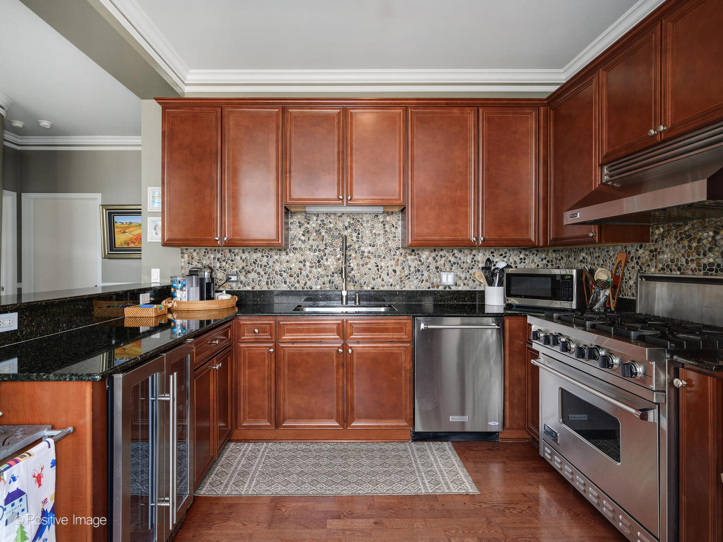 233 East 13th Street, Unit 1209 Chicago, IL 60605 - Photo 16 of 28 a kitchen with stainless steel appliances granite countertop a stove top oven a sink and dishwasher a oven with wooden cabinets