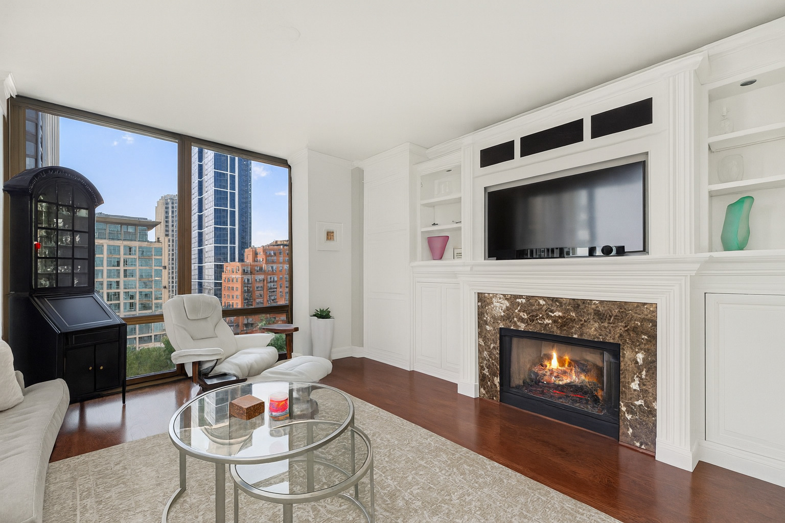 233 East 13th Street, Unit 1209 Chicago, IL 60605 - Photo 8 of 28 a living room with furniture a flat screen tv and a fireplace