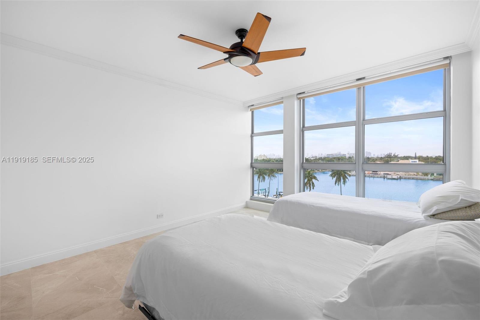 5055 Collins Avenue, Unit 6M Miami Beach, FL 33140 - Photo 13 of 42 a bed sitting in a bedroom next to a window
