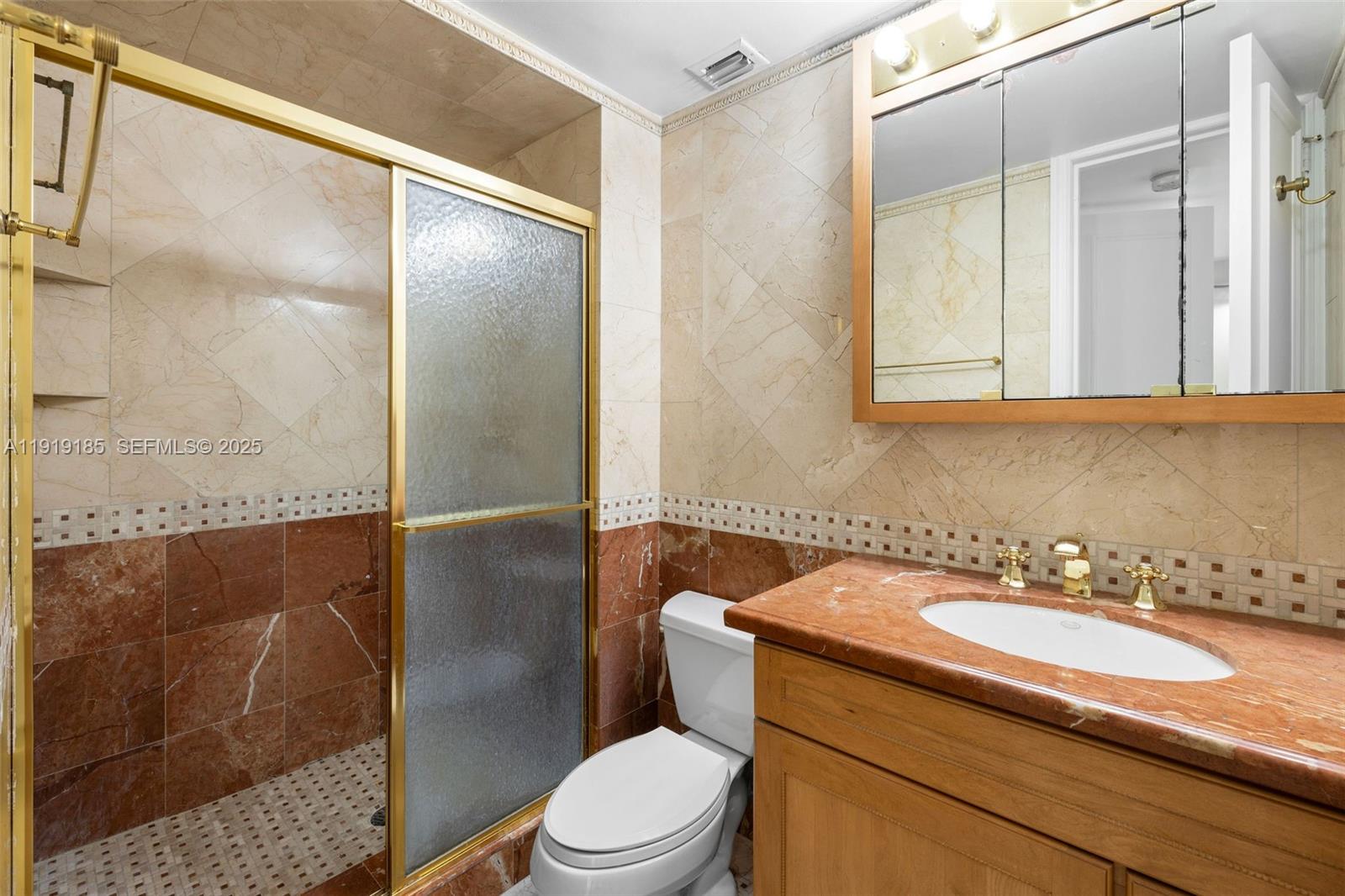 5055 Collins Avenue, Unit 6M Miami Beach, FL 33140 - Photo 20 of 42 a bathroom with a sink a toilet and shower