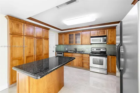 a kitchen with stainless steel appliances granite countertop a stove a sink and a refrigerator