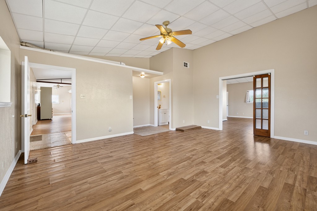 8804 Williamson Road Buda, TX 78610 - Photo 13 of 37 Warm wood flooring and vaulted ceilings design this versatile open interior space.