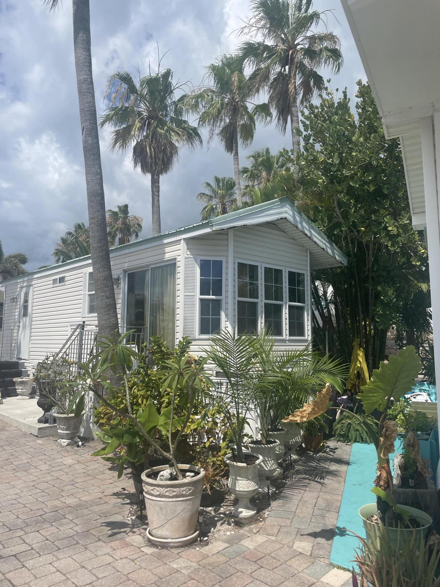 900 Juno Ocean Walk, Unit C34 Juno Beach, FL 33408 - Photo 15 of 20 a front view of a house with a yard and potted plants