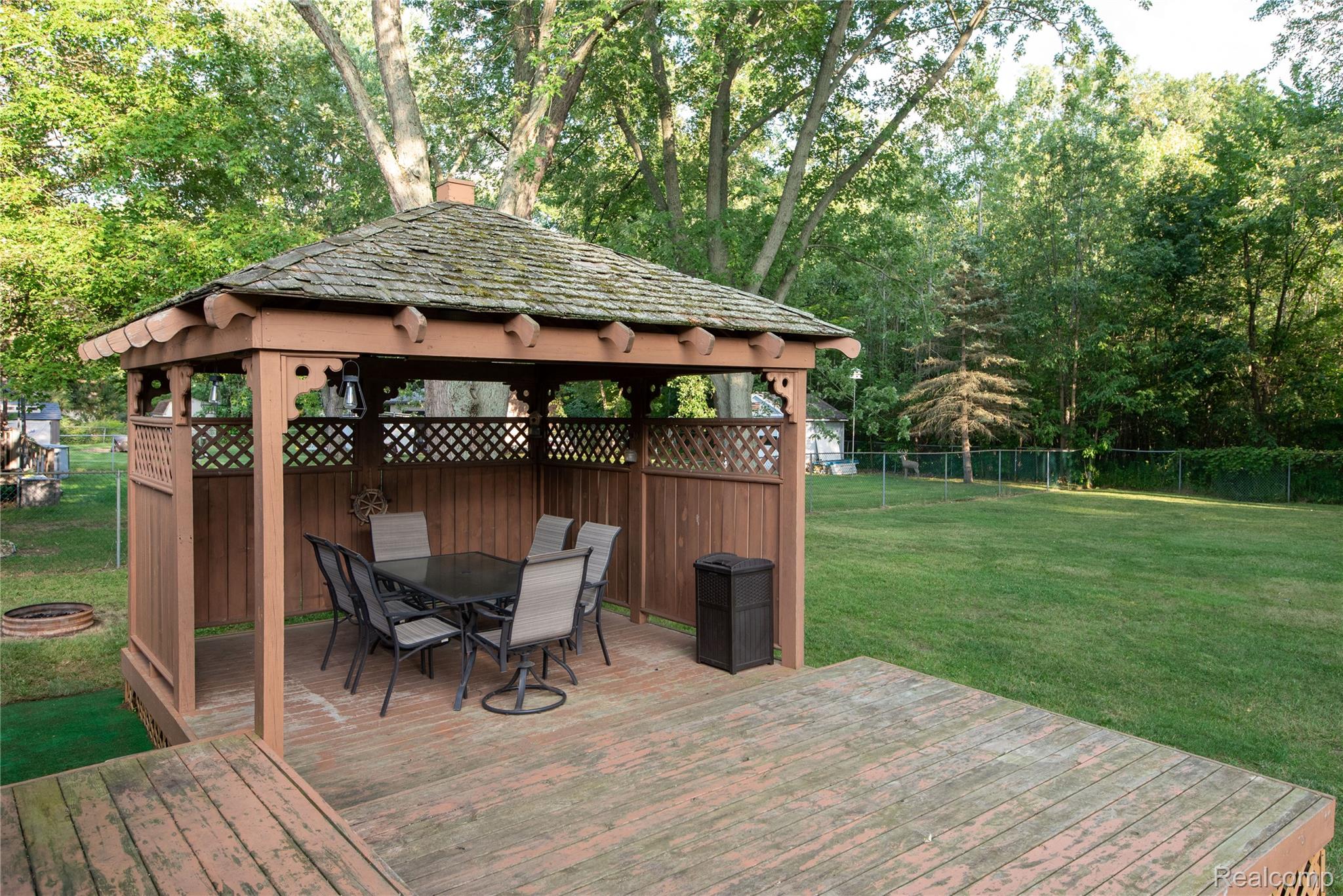 4395 Regency Road Swartz Creek, MI 48473 - Photo 60 of 67 Expansive backyard with a wooden deck featuring a built-in gazebo with lattice accents and a shingled roof
