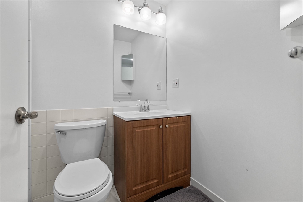 269 Cambridge Road, Unit 203 Woburn, MA 01801 - Photo 16 of 26 a bathroom with a toilet a sink and mirror