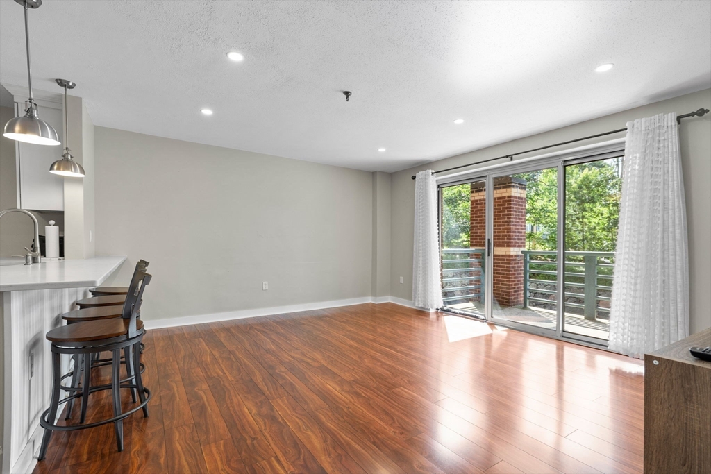 269 Cambridge Road, Unit 203 Woburn, MA 01801 - Photo 3 of 26 a view of an empty room with wooden floor and a window