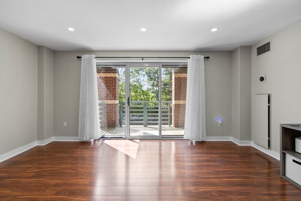 269 Cambridge Road, Unit 203 Woburn, MA 01801 - Photo 8 of 26 a view of empty room with wooden floor and fan