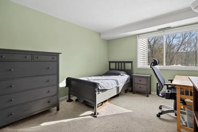 a bedroom with a bed and large windows