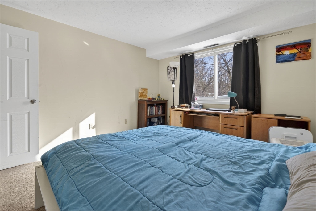 189 Littleton Road, Unit 59 Chelmsford, MA 01824 - Photo 13 of 17 a bedroom with a large bed and a dresser