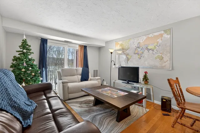 a living room with furniture a flat screen tv and a large window