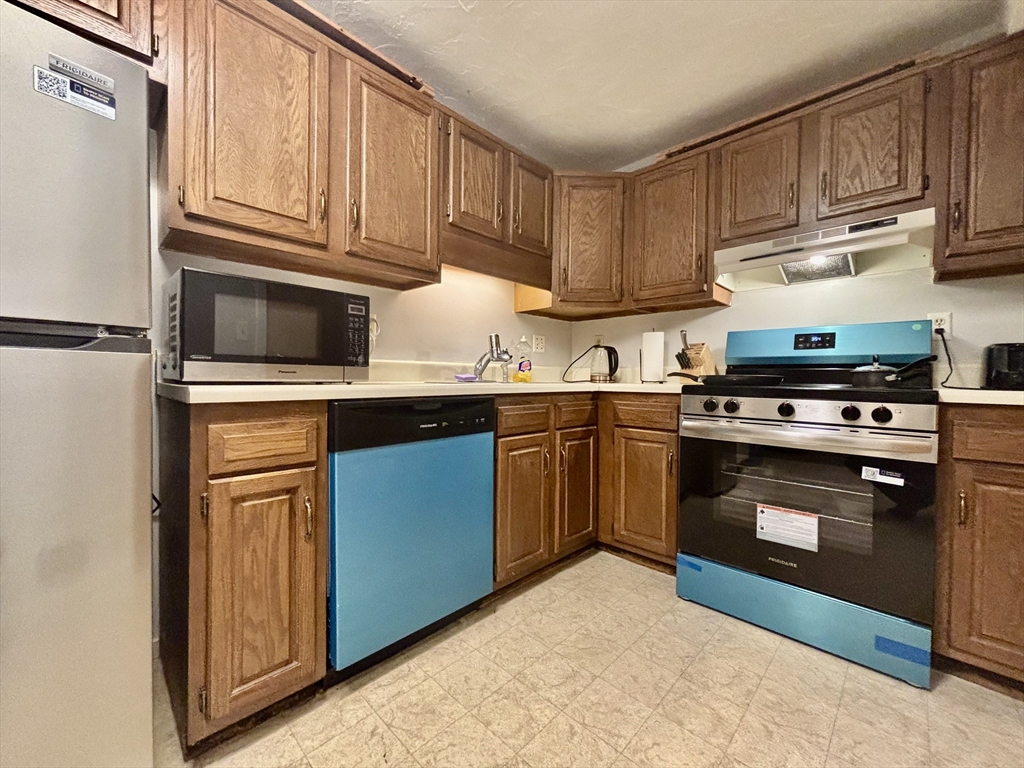 189 Littleton Road, Unit 59 Chelmsford, MA 01824 - Photo 8 of 17 a kitchen with stainless steel appliances granite countertop a stove microwave and cabinets