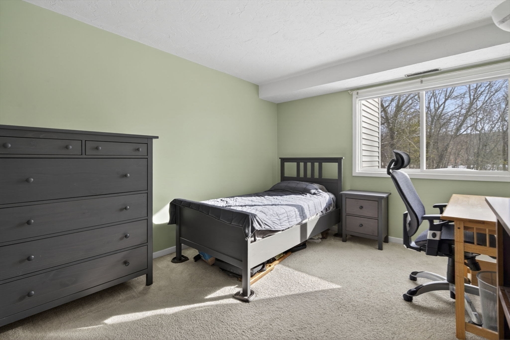 189 Littleton Road, Unit 59 Chelmsford, MA 01824 - Photo 10 of 17 a bedroom with a bed and large windows