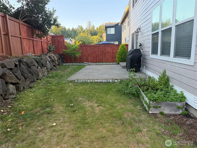a view of a backyard with plants and brick wall
