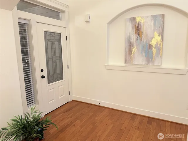 a kitchen with stainless steel appliances granite countertop a stove top oven a sink dishwasher a dining table and chairs with wooden floor