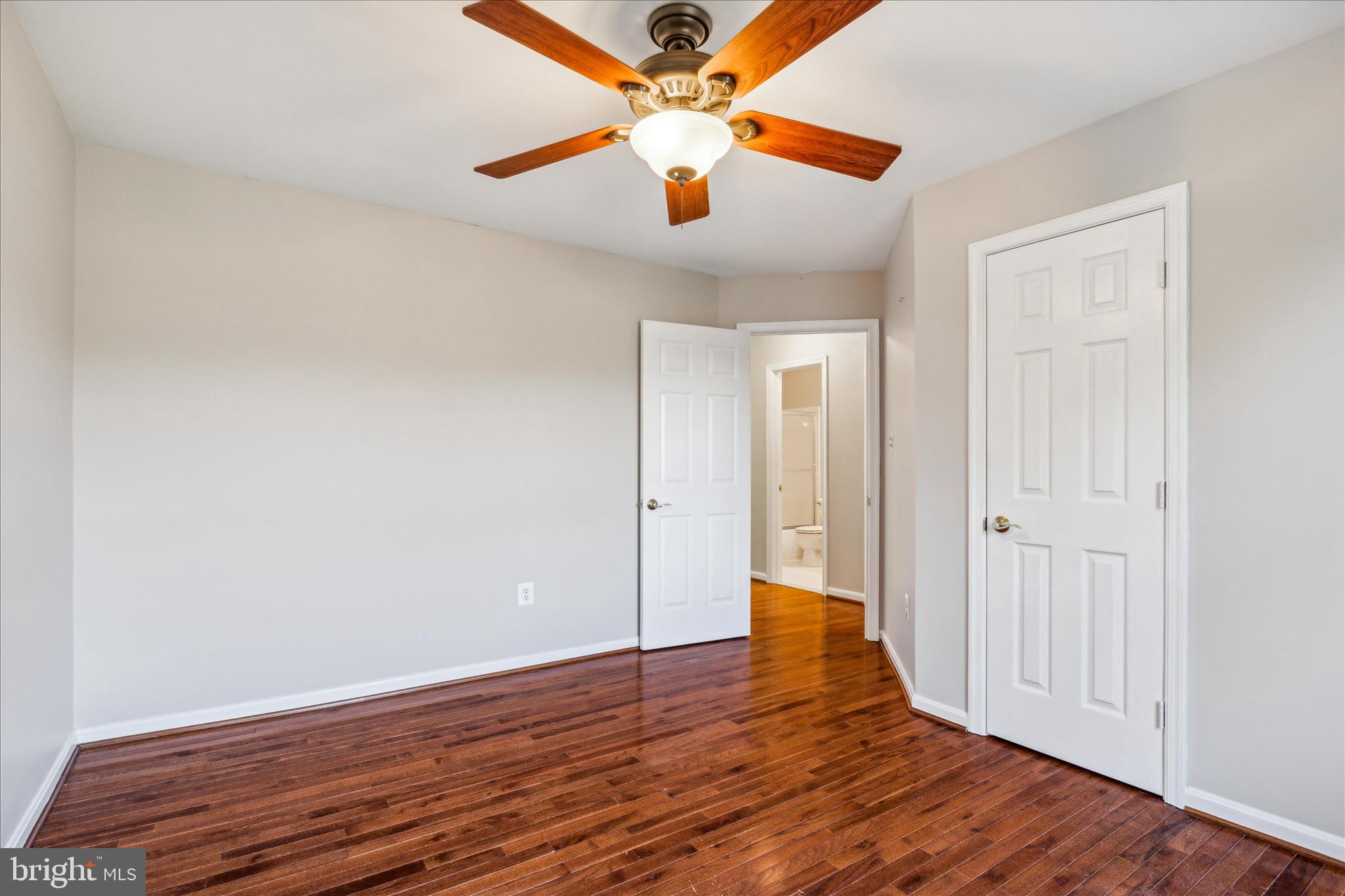 2442 Rippling Brook Road Frederick, MD 21701 - Photo 39 of 85 an empty room with wooden floor and a ceiling fan