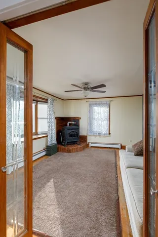 a view of an empty room with a fireplace and a window