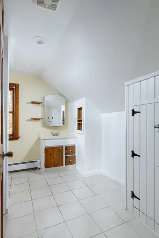 a spacious bathroom with a tub shower and mirror