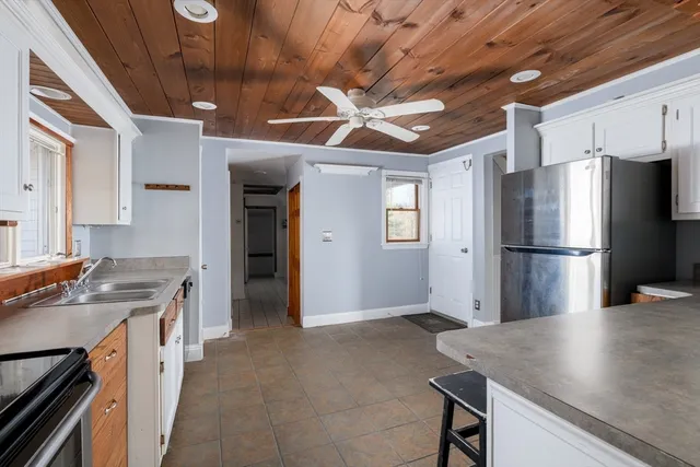 a kitchen with stainless steel appliances granite countertop a refrigerator a stove and a sink with dishwasher