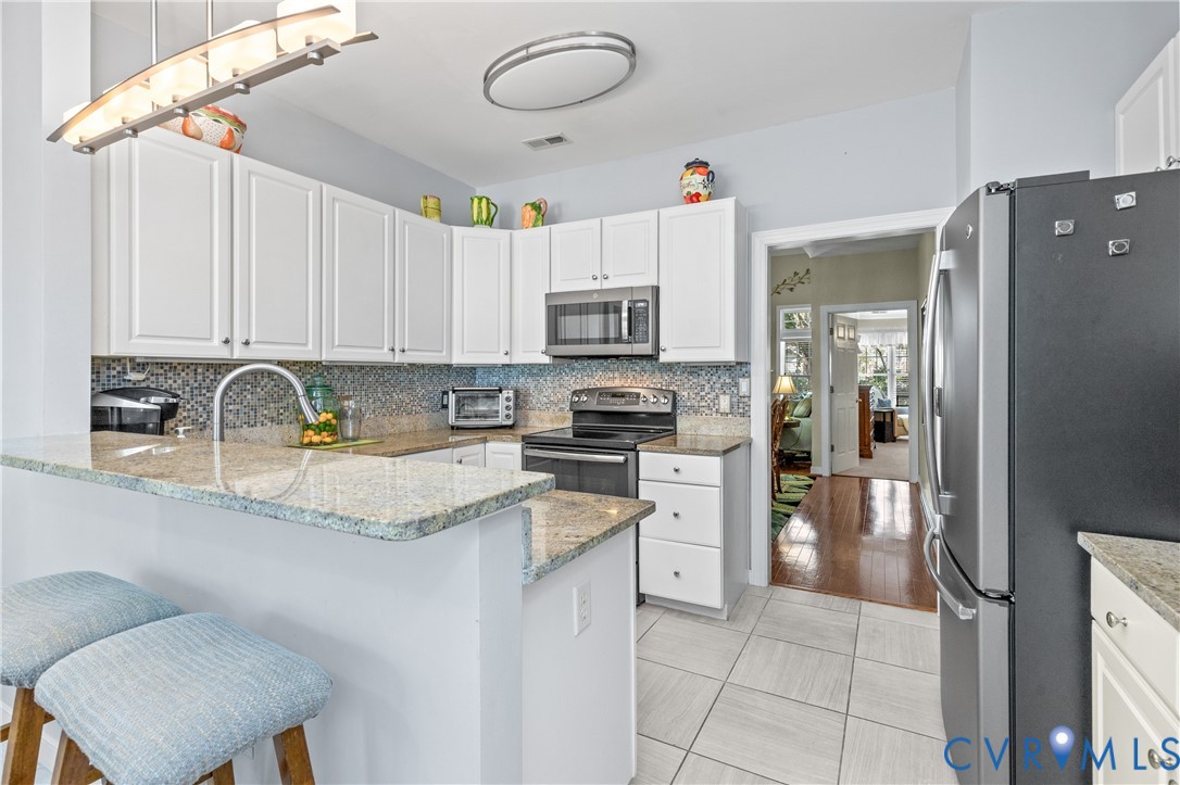 2205 Magnolia Grove Way Midlothian, VA 23113 - Photo 15 of 37 a kitchen with granite countertop a sink stainless steel appliances and cabinets