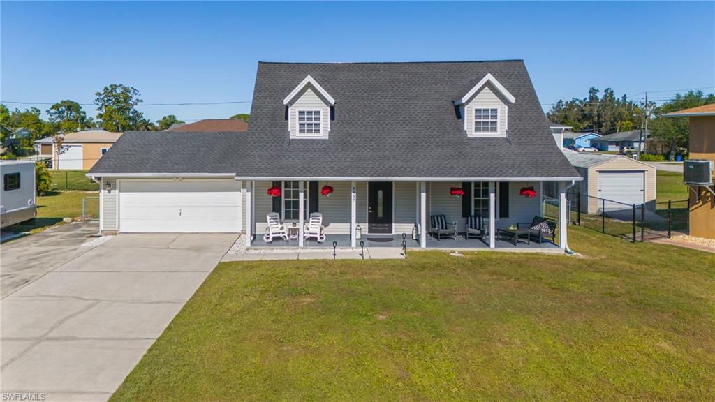 8457 Wren Road Fort Myers, FL 33967 - Photo 1 of 50 View of front of property with cooling unit, a porch, and a front yard
