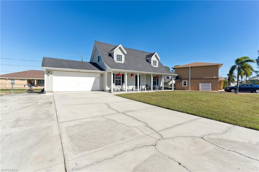8457 Wren Road Fort Myers, FL 33967 - Photo 12 of 50 Cape cod home with covered porch, a garage, and a front lawn