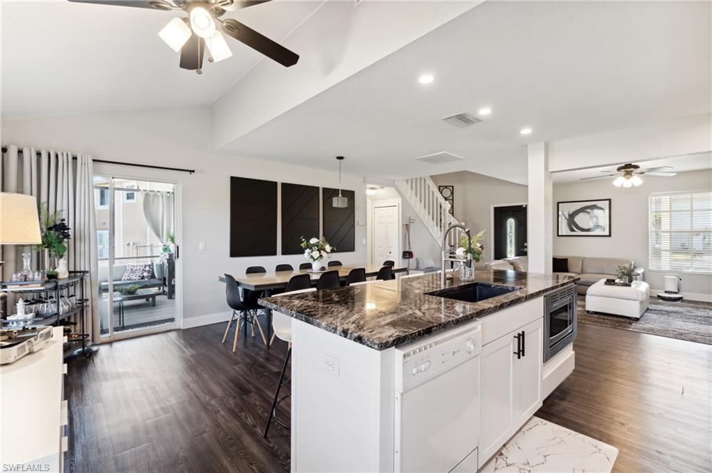 8457 Wren Road Fort Myers, FL 33967 - Photo 21 of 50 Kitchen with a kitchen breakfast bar, white dishwasher, sink, white cabinetry, and lofted ceiling