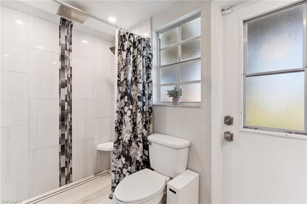 8457 Wren Road Fort Myers, FL 33967 - Photo 27 of 50 Bathroom with hardwood / wood-style floors, toilet, and a shower with curtain