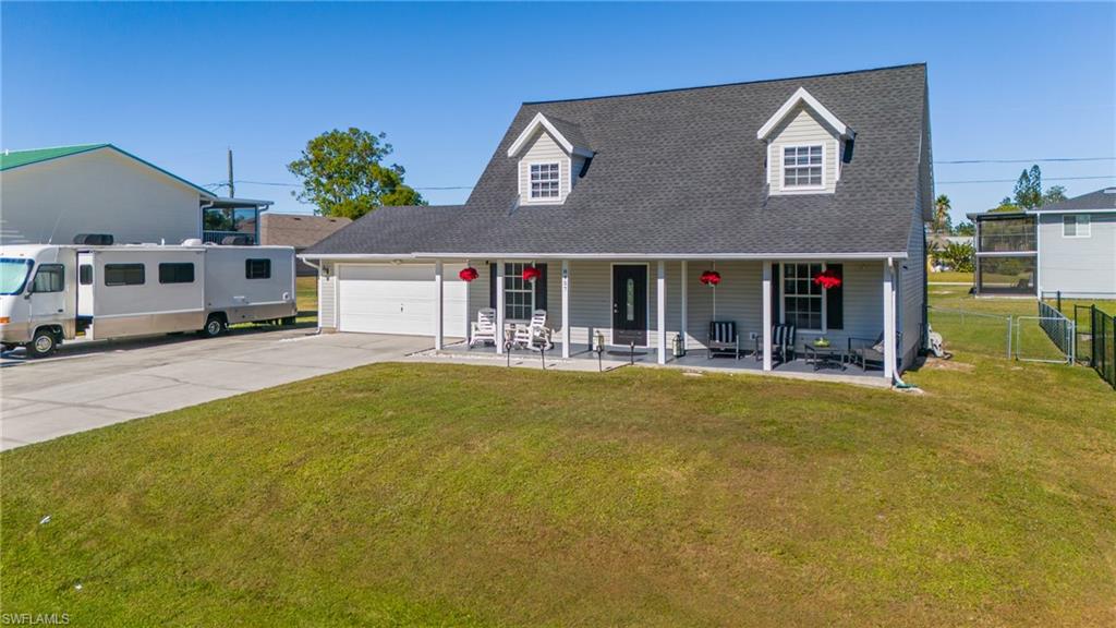 8457 Wren Road Fort Myers, FL 33967 - Photo 3 of 50 Cape cod house featuring covered porch, a garage, and a front lawn