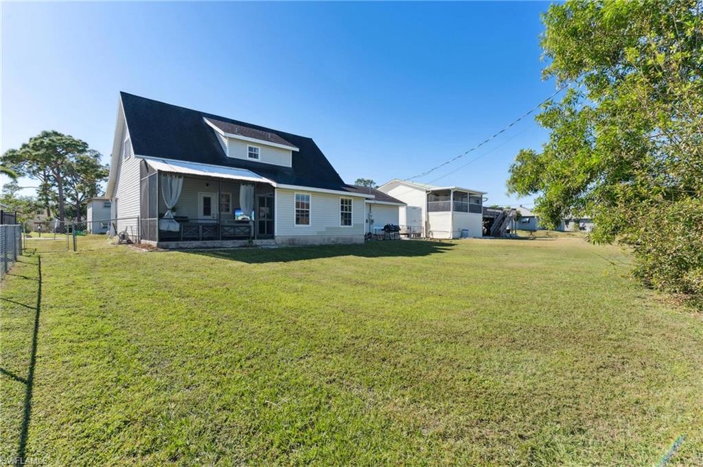 8457 Wren Road Fort Myers, FL 33967 - Photo 42 of 50 Back of property featuring a sunroom and a yard