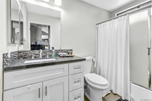 a bathroom with a sink a toilet and shower curtain