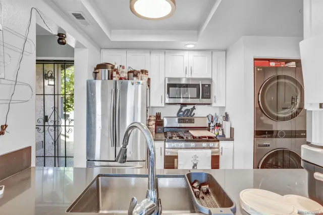 a kitchen with stainless steel appliances granite countertop a refrigerator and a sink