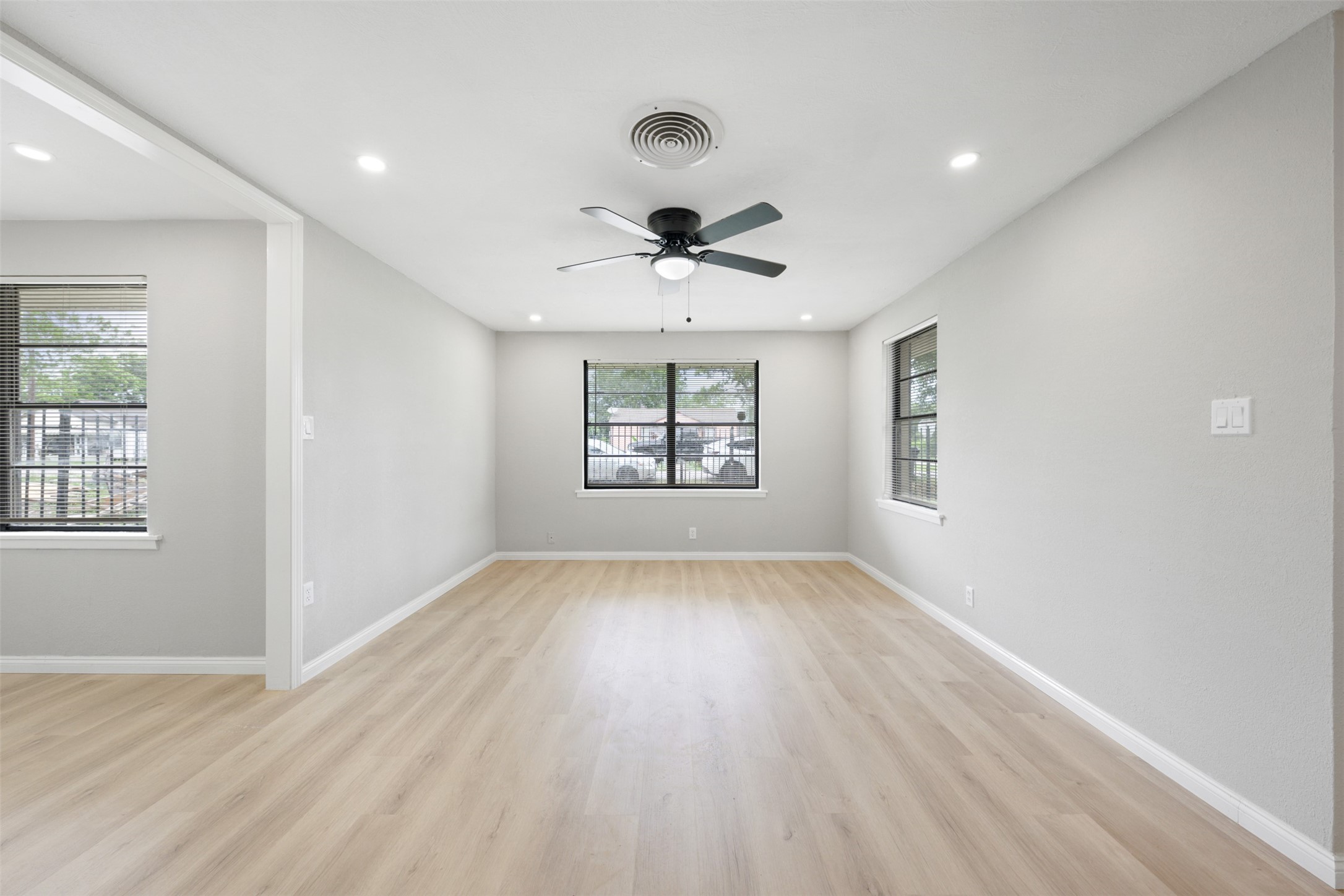 4356 Phlox Street Houston, TX 77051 - Photo 13 of 25 an empty room with wooden floor chandelier fan and windows