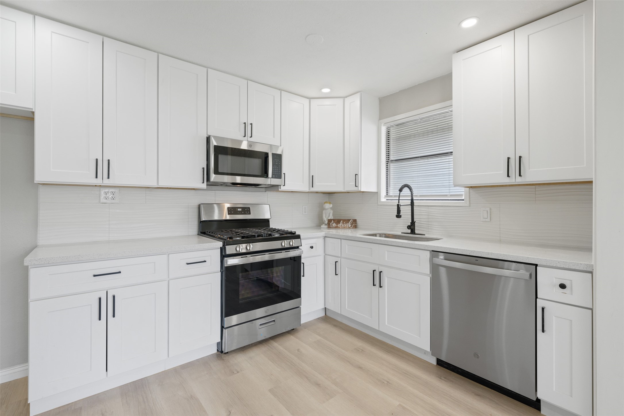4356 Phlox Street Houston, TX 77051 - Photo 9 of 25 a kitchen with granite countertop white cabinets and stainless steel appliances