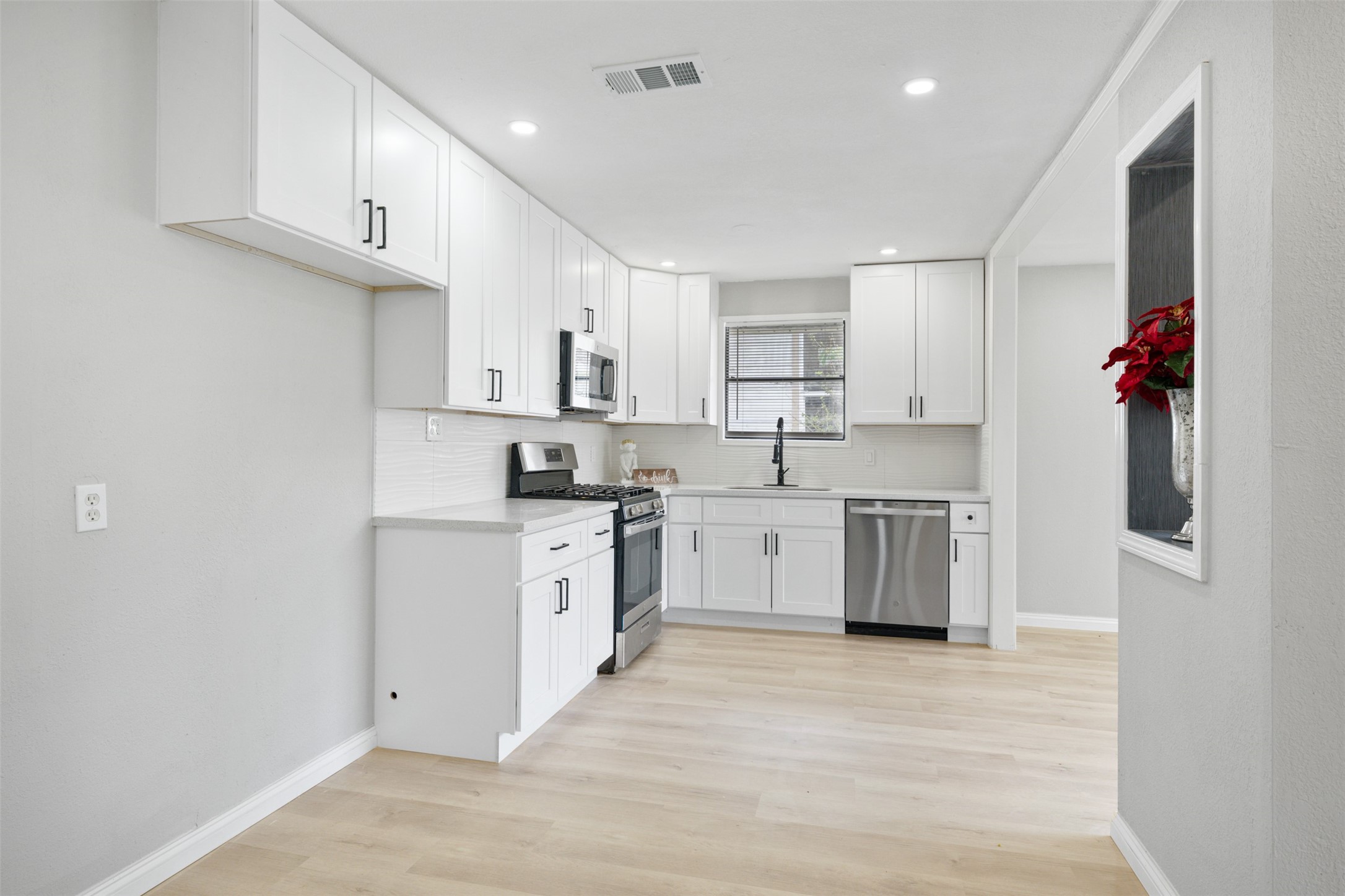 4356 Phlox Street Houston, TX 77051 - Photo 10 of 25 a kitchen with kitchen island granite countertop a sink cabinets and stainless steel appliances